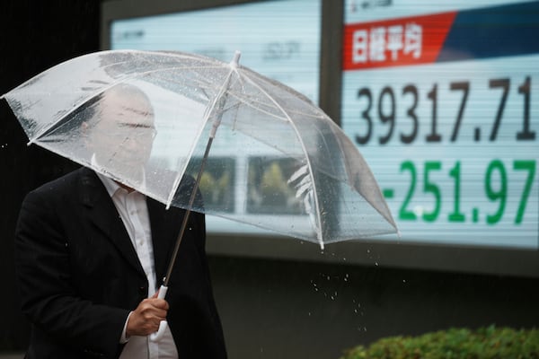 A person walks in front of an electronic stock board showing Japan's Nikkei index at a securities firm Monday, July 14, 2025, in Tokyo. (AP Photo/Eugene Hoshiko)