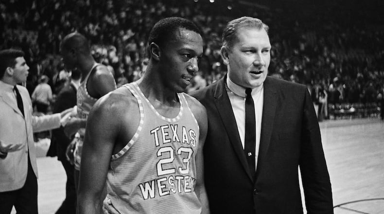 Texas Western Coach Don Haskins, right, escorts Orsten Artis off the court after the Miners came out on top in the NCAA semi-final game with Utah at the University of Maryland, March 19, 1966, College Park, Md. Texas western won 85-78 with Artis leading his teammates with 22 points. (AP Photo)
