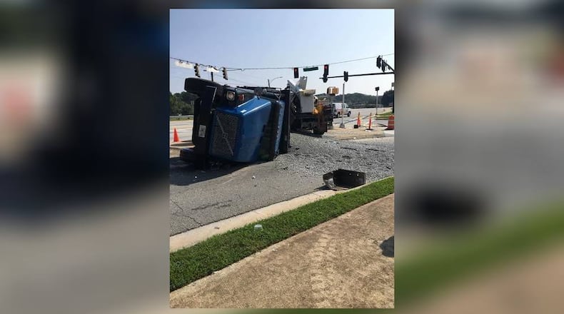 A dump truck ran a red light, overturned and spilled 18 tons of gravel on the I-20 overpass at West Avenue, according to Conyers police.