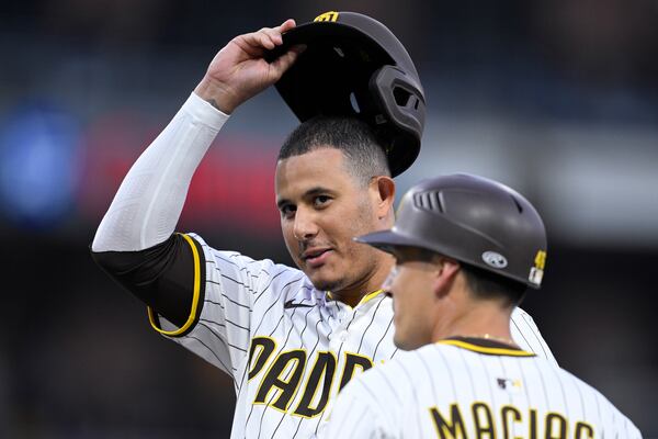 San Diego Padres' Manny Machado, left, acknowledges the crowd after hitting a single, his 2000th career hit, during the fourth inning of a baseball game against the Arizona Diamondbacks, Monday, July 7, 2025, in San Diego. (AP Photo/Orlando Ramirez)