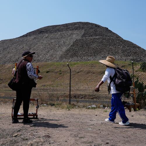 Handicraft vendors and tourists stand outside the Teotihuacan pyramids, which remained closed a day after a gunman opened fire on tourists at the archaeological site on the outskirts of Mexico City, Tuesday, April 21, 2026. (AP Photo/Marco Ugarte)