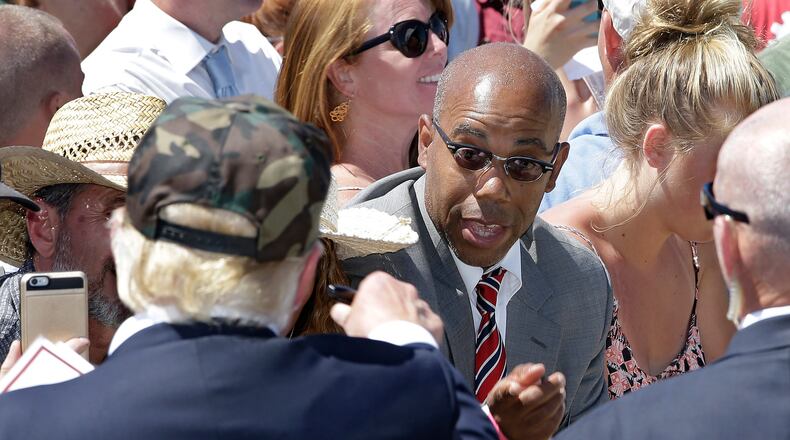In this photo taken June 3, 2016, Republican presidential candidate Donald Trump, left, talks to Gregory Cheadle as he leaves a campaign rally at the Redding Municipal Airport, in Redding, Calif.