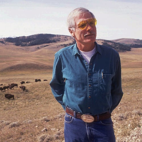 FILE - Ted Turner poses near a herd of his bison in September 1991 at his Flying D Ranch near Bozeman, Mont. (Linda Best/Bozeman Daily Chronicle via AP, File)