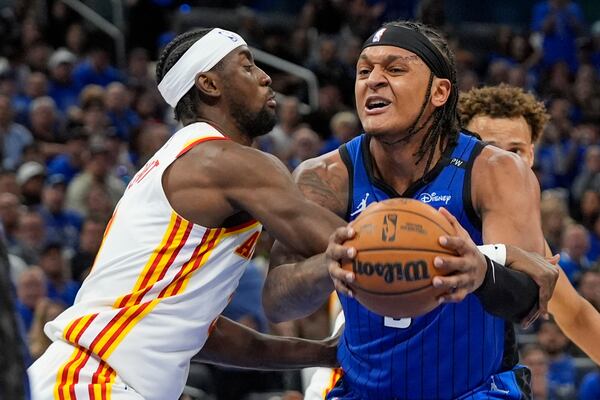 Orlando Magic forward Paolo Banchero, right, is fouled by Atlanta Hawks guard Caris LeVert, left, as he goes up for a shot during the second half of an NBA play-in tournament basketball game, Tuesday, April 15, 2025, in Orlando, Fla. (AP Photo/John Raoux)