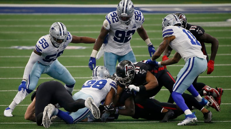 Dallas' Justin March (59) and Dorance Armstrong (92) look on as C.J. Goodwin (29) recovers an onside kick against the Falcons late in the game Sunday, Sept. 20, 2020, in Arlington, Texas. (Ron Jenkins/AP)