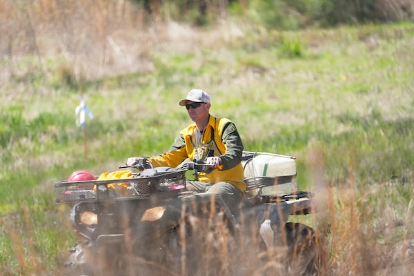 A fire crew member drives back to a staging site while working to contain the Pauline Road wildfire Thursday, March 20, 2025, in Cleveland, Texas. (AP Photo/David J. Phillip)