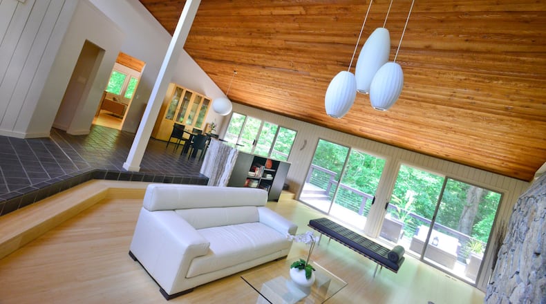 Living room The tri-pendant in living room was custom designed by Studio R Squared. “In the living room, I have a whole row of windows really all the way up to the top of the ceiling and that’s where all the light comes in,” Janice said. The gas fireplace in the living room, family room and master bedroom have a tempered glass treatment from Metro House of Fire. George Nelson Pendants in the entry, living room, and dining room are from Design Within Reach. Ceiling fans in the in the living, kitchen, master bedroom, sunroom, family room and gym are the Lapa Modern Fan from Illuminations Lighting.(Christopher Oquendo Photography)