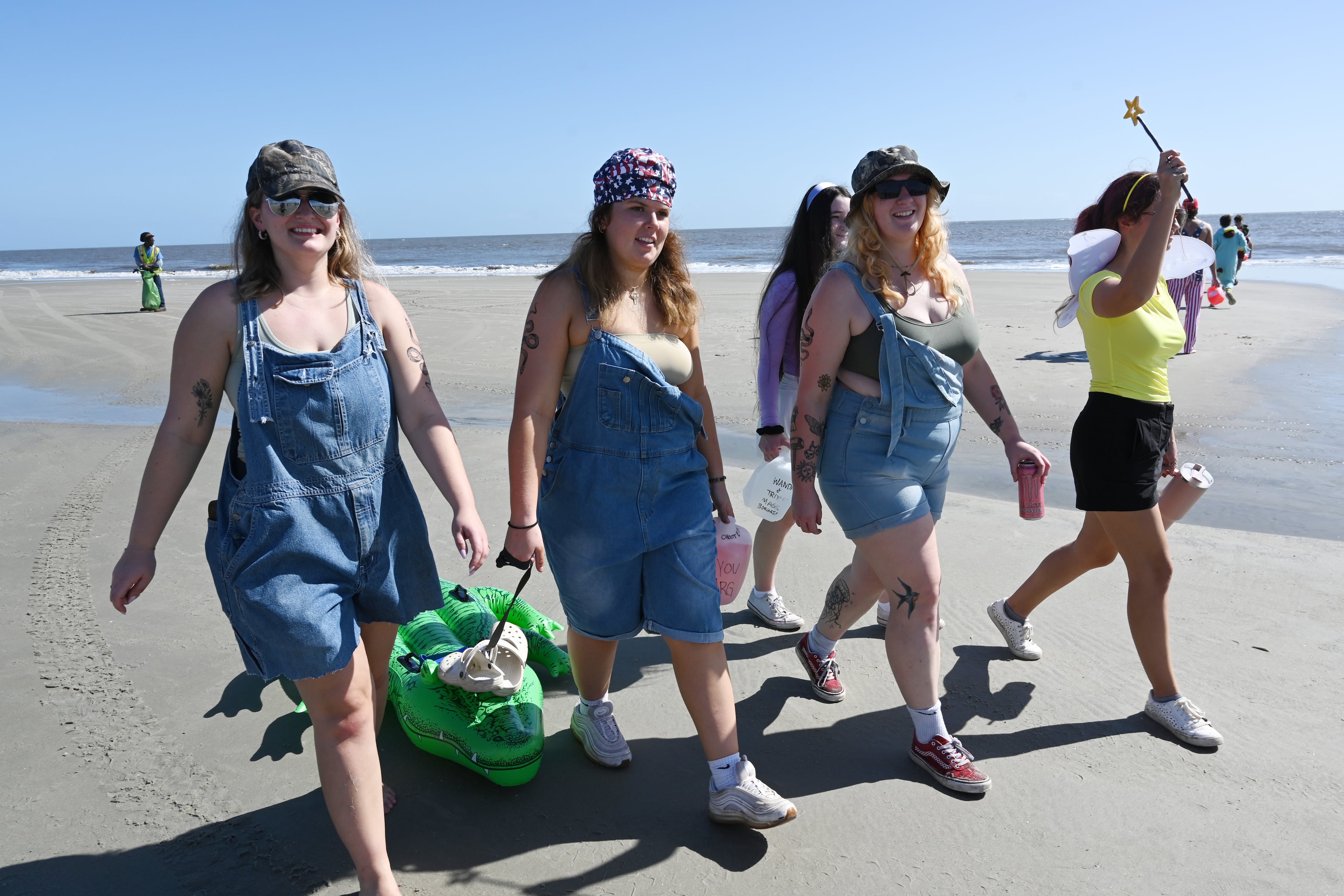 Laney Brock (second from left) drags an alligator tube during the annual “Frat Beach” party for the weekend of the Georgia-Florida football game on St. Simons Island, Friday, November 1, 2024. On the weekend of the Georgia-Florida football game, St. Simons Island’s East Beach becomes “Frat Beach,” an open-air party teeming with thousands of college students. (Hyosub Shin / AJC)