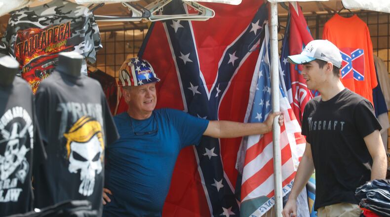 Souvenir vendor Ed Sugg, left, talks with a customer at his facility near Talladega Superspeedway prior to a NASCAR Cup Series auto race in Talladega Ala., Sunday, June 21, 2020.