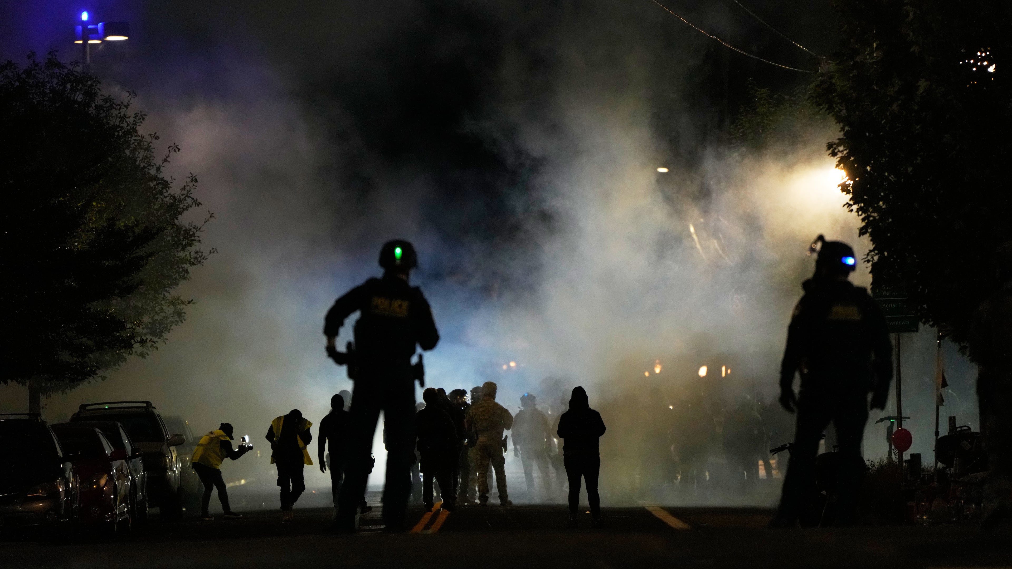 Law enforcement officers stand after deploying tear gas outside a U.S. Immigration and Customs Enforcement facility during a protest on Saturday, Oct. 4, 2025, in Portland, Ore. (AP Photo/Jenny Kane)