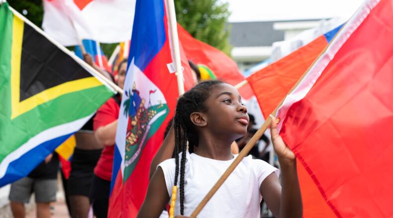 A young festivalgoer holds up the Moroccan flag during the flag parade at the "Around the World in the DTL" in Lawrenceville, Ga. September 9, 2022. (Kendra A. Ransum/Fresh Take Georgia)