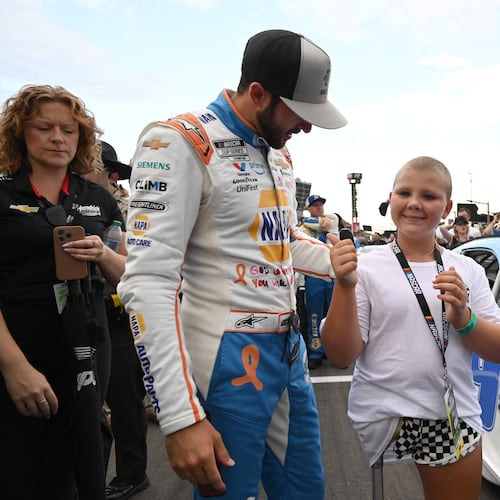 Rhealynn Mills, 11, talks with NASCAR Cup Series driver Chase Elliott before the Quaker State 400 at EchoPark Speedway on Saturday, June 28, 2025, in Hampton. Mills, a cancer patient at Children’s Healthcare of Atlanta, recently won a contest for her artwork to appear on Elliott's car. (Hyosub Shin/AJC)