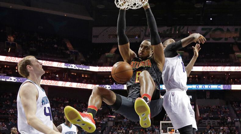 Atlanta Hawks’ Dwight Howard, center, dunks against Charlotte Hornets’ Michael Kidd-Gilchrist, right, and Cody Zeller, left, during the second half of an NBA basketball game in Charlotte, N.C., Monday, March 20, 2017. The Hornets won 105-90. (AP Photo/Chuck Burton)