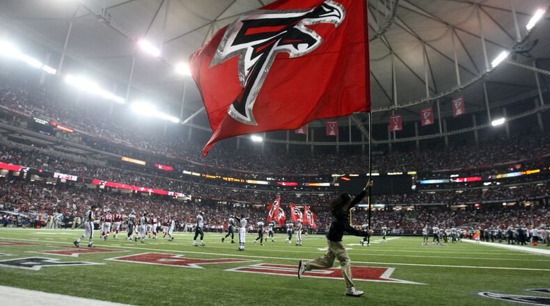 Atlanta Falcon flags are ran onto the field after a Falcons touchdown during their  win over the Philadelphia Eagles at the Georgia Dome in Atlanta, Ga. Jason Getz jgetz@ajc.com