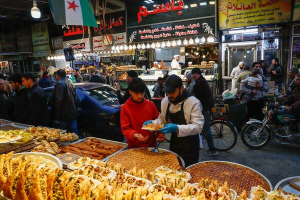 FILE.- A boy buys sweets on the first day of Ramadan, the holy month for Muslims, in Damascus, Syria, Saturday March 1, 2025.(AP Photo/Omar Sanadiki,File)