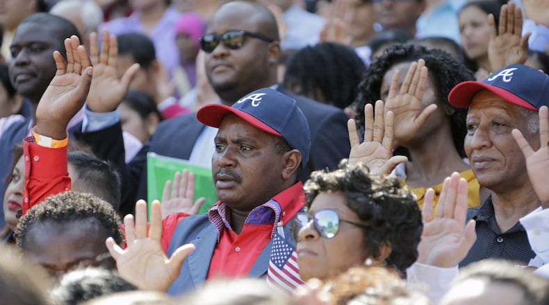 New citizens take their oath of allegiance during a naturalization ceremony at Turner Field. BOB ANDRES /BANDRES@AJC.COM