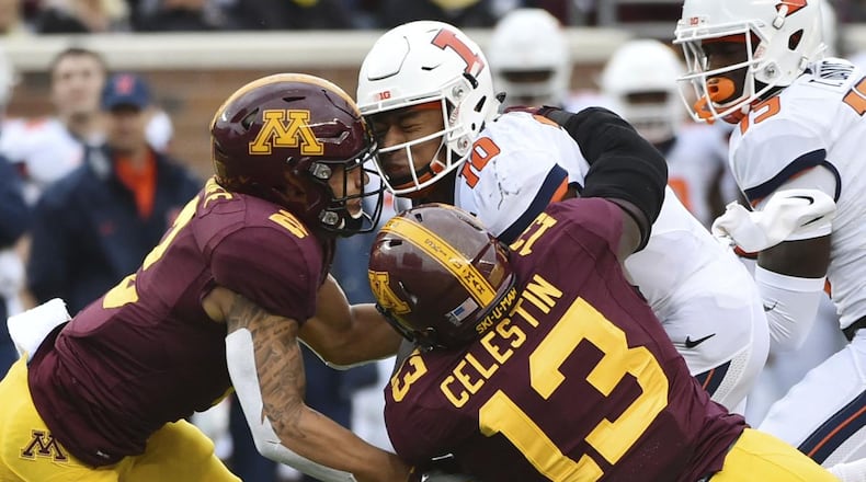 Minnesota defensive back Jacob Huff, left, and linebacker Jonathan Celestin combine to stop Illinois quarterback Cam Thomas. (ASSOCIATED PRESS )