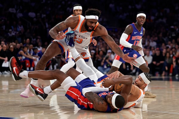 New York Knicks center Mitchell Robinson (23) and Josh Hart fight for a loose ball with Detroit Pistons forward Paul Reed during Game 5 in an NBA basketball first-round playoff series Tuesday, April 29, 2025, in New York. (AP Photo/Adam Hunger)