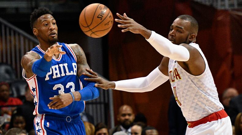 Philadelphia 76ers forward Robert Covington (33) passes as Atlanta Hawks forward Paul Millsap defends during the first half of an NBA basketball game, Saturday, Jan. 21, 2017, in Atlanta. (AP Photo/John Amis)