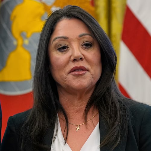 FILE - Labor Secretary Lori Chavez-DeRemer listens as President Donald Trump speaks with reporters while signing executive orders in the Oval Office of the White House, April 23, 2025, in Washington. (AP Photo/Alex Brandon, File)
