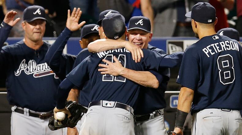 Atlanta Braves' interim manager Brian Snitker embraces Braves' center fielder Ender Inciarte (11) who still has the ball limn his hand after robbing New York Mets Yoenis Cepedes of a game-winning, three-run home run for the final out in the ninth inning of the Braves' 4-3 victory over the Mets in a baseball game, Wednesday, Sept. 21, 2016, in New York. (AP Photo/Kathy Willens)