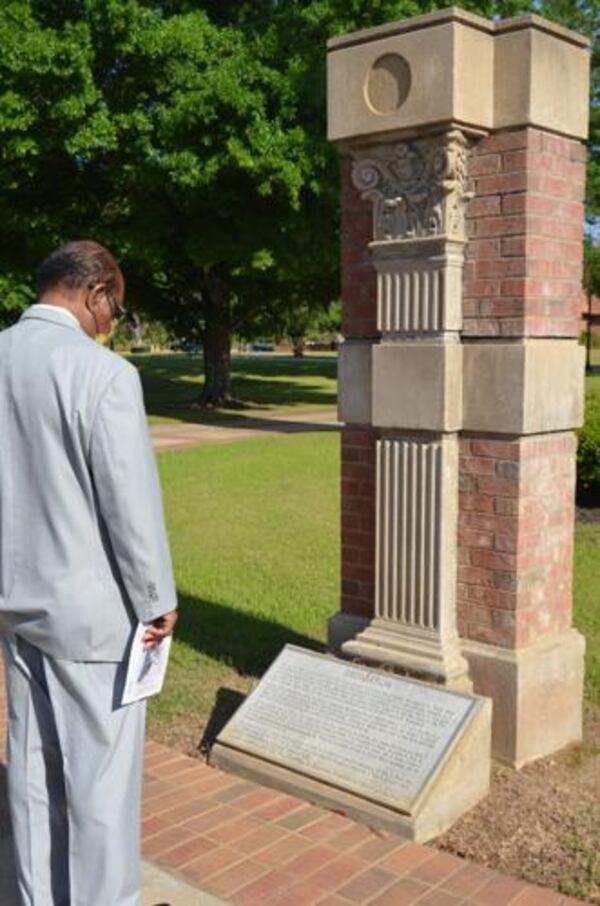William A. Hopkins, a 1968 Albany State University graduate, stands at a plaque commemorating the 1994 flood that devasted much of the campus. (Photo Courtesy of Alan Mauldin)