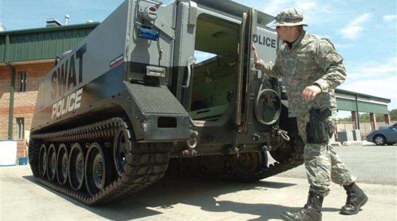 070410 Doraville Ga: Officer M. Joseph Shirley of the Doraville SWAT Perimeter Unit is an Operator of the M13 vehicle. He is giving the photographer a tour of the M13. Georgia police benefit from Pentagon surplus equipment program. Law enforcement agencies in small Georgia communities benefit from a Pentagon program in which these departments can get at no cost everything from helicopters and armored vehicles to uniforms, weapons and boots. The program re-uses excess material purchased by the taxpayers without the locals having to pay out more for big-ticket items that normally would be out of reach for many small-town budgets. April 10, 2007 (Renee' Hannans Henry/Staff). Police have been obtaining surplus military equipment for years. The AJC photo archives contains this picture from 2007 of Doraville police with a M13 vehicle.