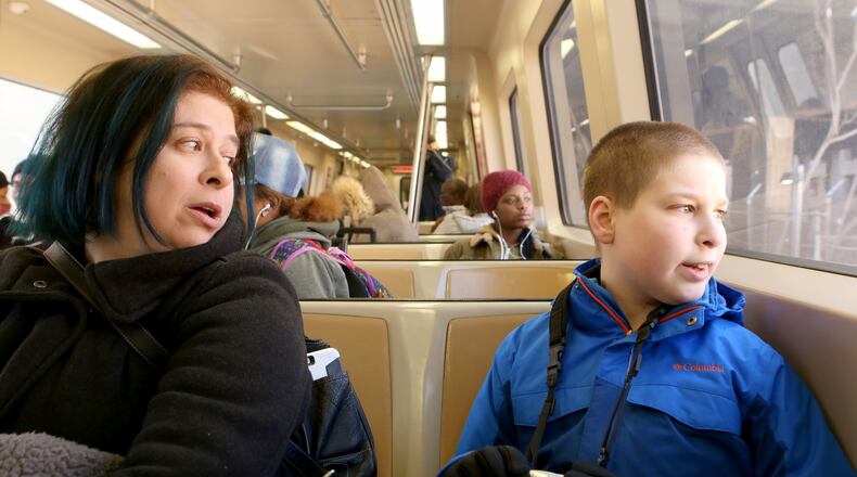 Gabriel and his mother Alison sit aboard a MARTA train. (HENRY TAYLOR / HENRY.TAYLOR@AJC.COM)