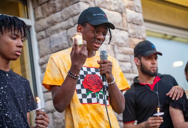 Family and friends, including David Allen (center), mourn the loss of 16-year-old Jacob Johnson at a candlelight vigil and balloon release Tuesday evening.