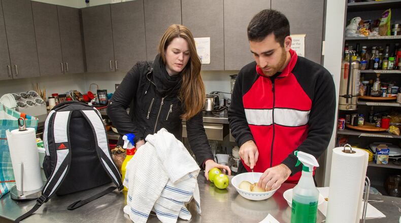 Mathilde Gondard (left) from France and Samer Bou Karroum from Lebanon prepares their own food in the community kitchen at Villa International where researchers and medical students from around the world who want to tap into the expertise of the CDC and Emory’s Rollins School of Medicine can stay. Photo by Phil Skinner