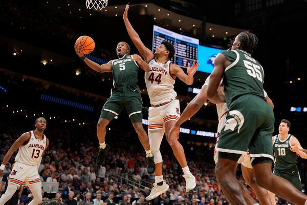 Michigan State guard Tre Holloman (5) shoots against Auburn center Dylan Cardwell (44) during the second half in the Elite Eight of the NCAA college basketball tournament, Sunday, March 30, 2025, in Atlanta. (AP Photo/George Walker IV)