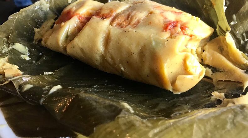 The Tamal Colombiano at El Kiosco in Marietta is made from corn masa and filled with chunks of pork, chicken, chorizo and beef, served atop a plantain leaf. LIGAYA FIGUERAS / LFIGUERAS@AJC.COM