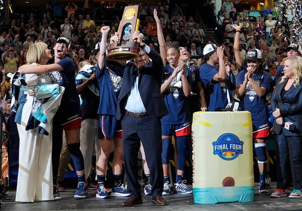 UConn head coach Geno Auriemma holds up the championship trophy after UConn defeated South Carolina in the national championship game at the Final Four of the women's NCAA college basketball tournament, Sunday, April 6, 2025, in Tampa, Fla. (AP Photo/John Raoux)