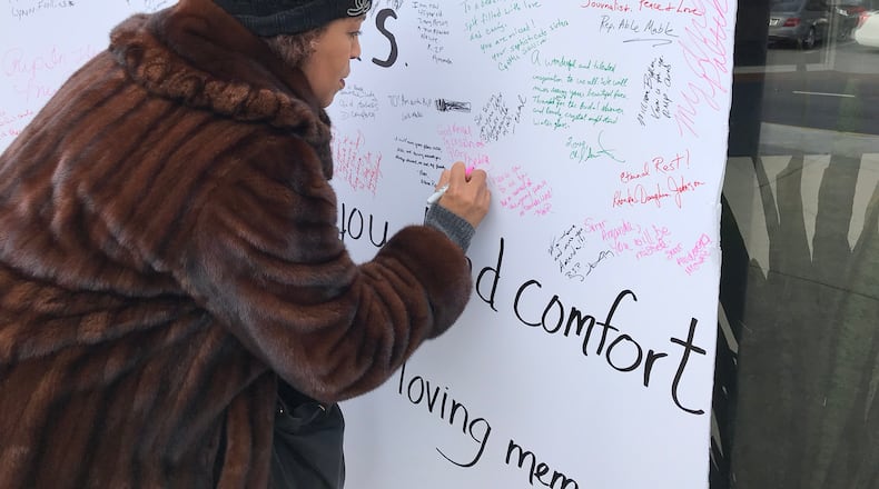 Debra Buffett, a friend of Amanda Davis, signs an oversized condolence card outside Cascade United Methodist Church just as Davis' funeral services were beginning January 3, 2018. CREDIT: Rodney Ho/rho@ajc.com