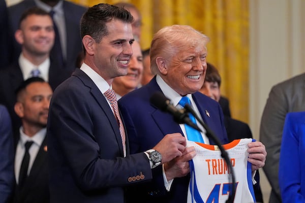 President Donald Trump and head coach Todd Golden poses with a jersey as Trump hosts the 2025 NCAA Champion, University of Florida men's basketball team in the East Room of the White House, Wednesday, May 21, 2025, in Washington. (AP Photo/Julia Demaree Nikhinson)