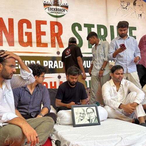 Abhijeet Dipke, founder of the Cockroach Janta Party, center sitting, starts his indefinite hunger strike during a protest demanding the resignation of Education Minister Dharmendra Pradhan over alleged examination irregularities and repeated paper leaks in New Delhi, India, Saturday, July 18, 2026. (AP Photo/Shonal Ganguly)
