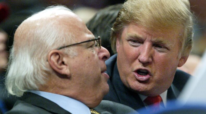 FILE - Donald Trump, right, talks to an unidentified man from the stands at Madison Square Garden during the New York Knicks game against the Dallas Mavericks on Jan. 11, 2006, in New York. (AP Photo/Kathy Willens, File)