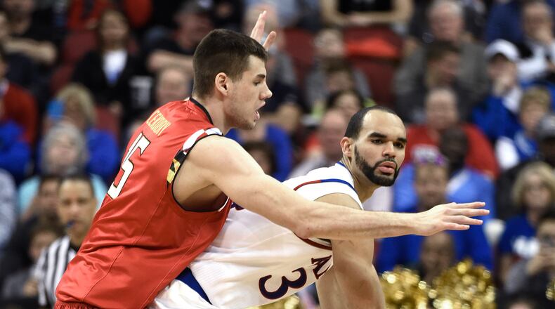 Kansas forward Perry Ellis (34) is guarded by Maryland forward Michal Cekovsky (15) during the first half of an NCAA college basketball game in the regional semifinals of the men's NCAA Tournament in Louisville, Ky., Thursday, March 24, 2016. (AP Photo/John Flavell)