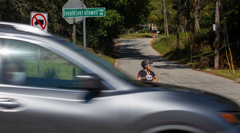Bicyclist Rolanda Powell waits to merge onto Donald Lee Hollowell Parkway from Center Hill Avenue in Atlanta. Rolanda Powell, head of her neighborhood organization, has been raising concerns about the safety of Hollowell Parkway. A crosswalk is now located at this intersection. (Photo/Rebecca Wright for the Atlanta Journal-Constitution)