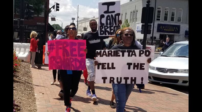 Lubreeze Lewis, right, marches in a protest held Friday in downtown Marietta against the treatment of her husband, Renardo Lewis.