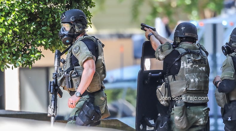 Marietta SWAT officers gather outside The Park on Windy Hill apartment complex on Windy Hill Road where a wanted man is hiding inside an attic Thursday morning.