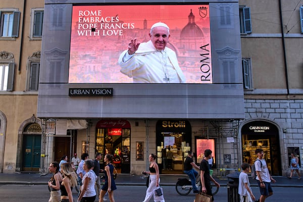 A street screen dedicated to Pope Francis reads "Rome hugs Francis with Love" in downtown Rome, Friday, May 2, 2025. (AP Photo/Bernat Armangue)