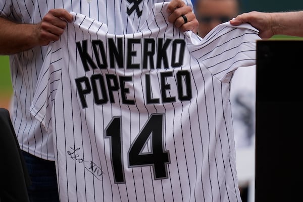 Cardinal Blase Cupich, right, presents former Chicago White Sox player Paul Konerko with a jersey signed by Pope Leo XIV during a ceremony honoring the 2005 World Series Champions before a baseball game between the Cleveland Guardians and Chicago White Sox, Saturday, July 12, 2025, in Chicago. (AP Photo/Erin Hooley)