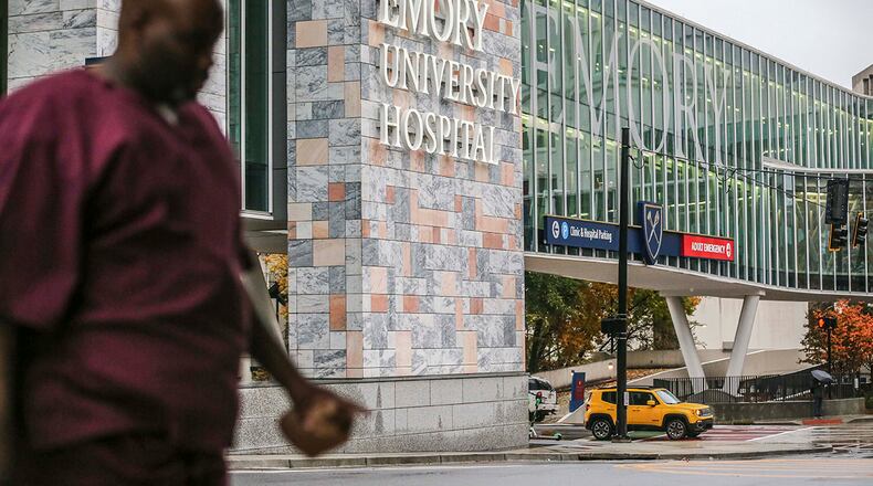 Medical personnel walk the campus at Emory Hospital. JOHN SPINK/JSPINK@AJC.COM