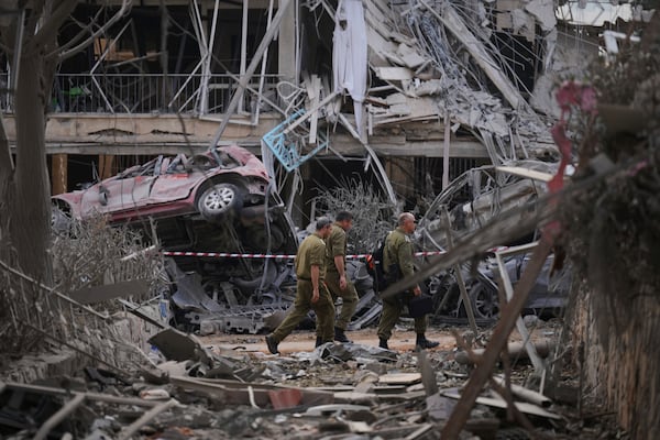 Israeli security forces inspect destroyed residential buildings that were hit by a missile fired from Iran, in Ramat Gan, near Tel Aviv, Israel on Saturday, June 14, 2025. (AP Photo/Ariel Schalit)