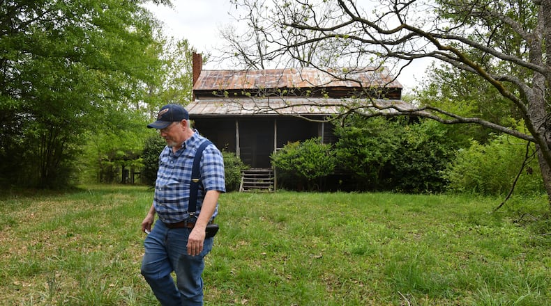 Michael Bolick, owner, shows Knox Cabin, a cabin that's at least 191 years old in Duluth, on Wednesday, April 14, 2021. It's possibly the oldest dovetail cabin in Gwinnett County, and it could be torn down to make way for a residential subdivision. The Duluth Historical Society is trying to collect donations from the community to move it to a new location. (Hyosub Shin / Hyosub.Shin@ajc.com)