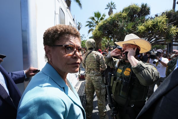 Los Angeles Mayor Karen Bass stands in front of a border patrol federal agent at MacArthur Park Monday, July 7, 2025, in Los Angeles. (AP Photo/Damian Dovarganes)