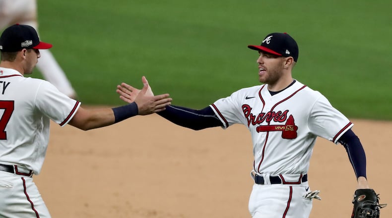 Atlanta Braves first baseman Freddie Freeman, right, celebrates with third baseman Austin Riley after a 10-2 win against the Los Angeles Dodgers in Game 4 of the National League Championship Series at Globe Life Field in Arlington, Texas, on Thursday, Oct. 15, 2020. The Braves now hold a 3-1 series lead. (Curtis Compton/Atlanta Journal-Constitution/TNS)
