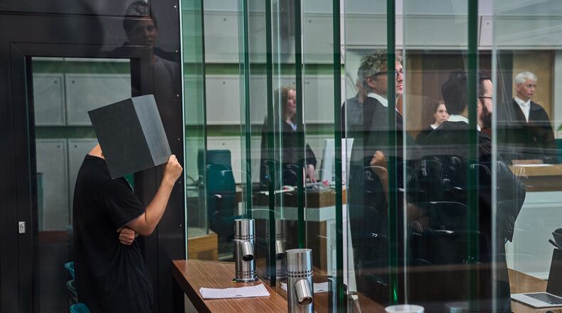 The defendant covering his face in the court during a trial against an online predator network of men accused of using chat groups to share tips on how to drug and rape women, in Berlin, Germany, Wednesday, July 8, 2026. (AP Photo/Ebrahim Noroozi)