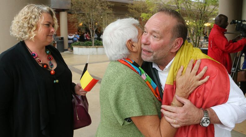 Emmanuelle Nadaud (from left), Michele Oliveres, and Patrick VanBiesen greet each other with a hug at a Belgium reception and Atlanta vigil for the Brussels terror on Thursday in Atlanta. Curtis Compton / ccompton@ajc.com